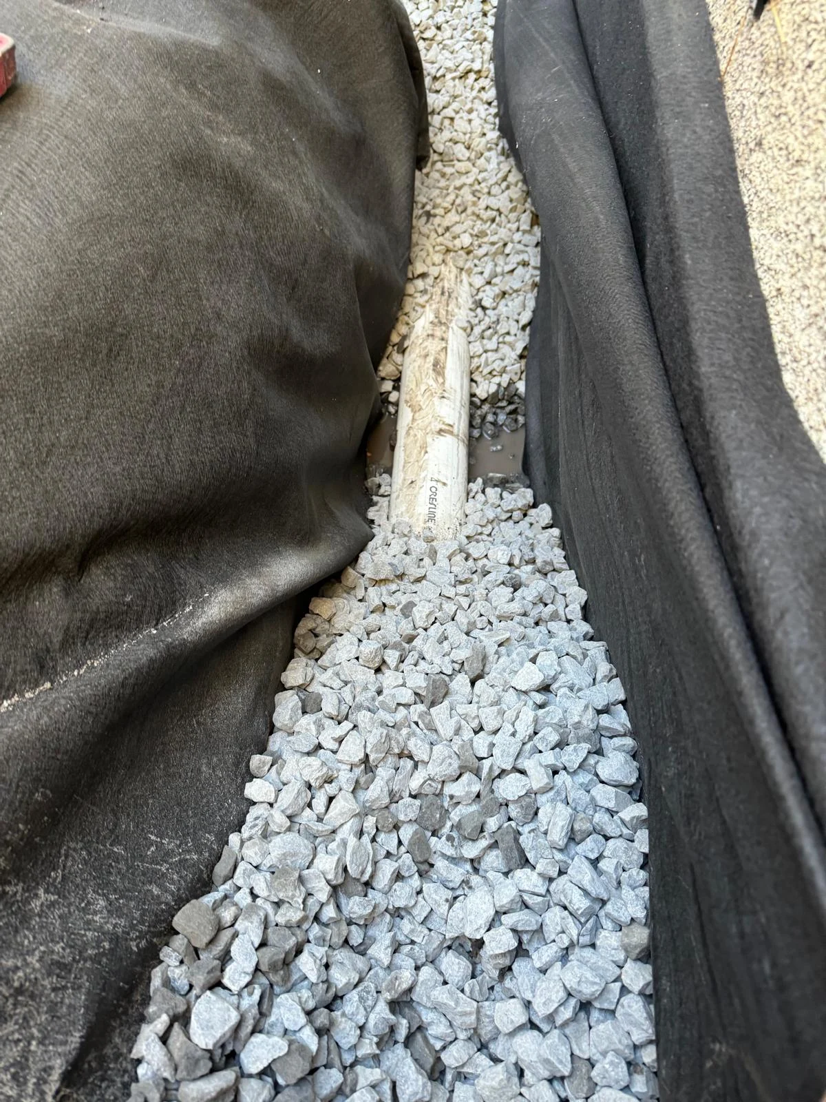 Gravel and protective lining in a French drain trench