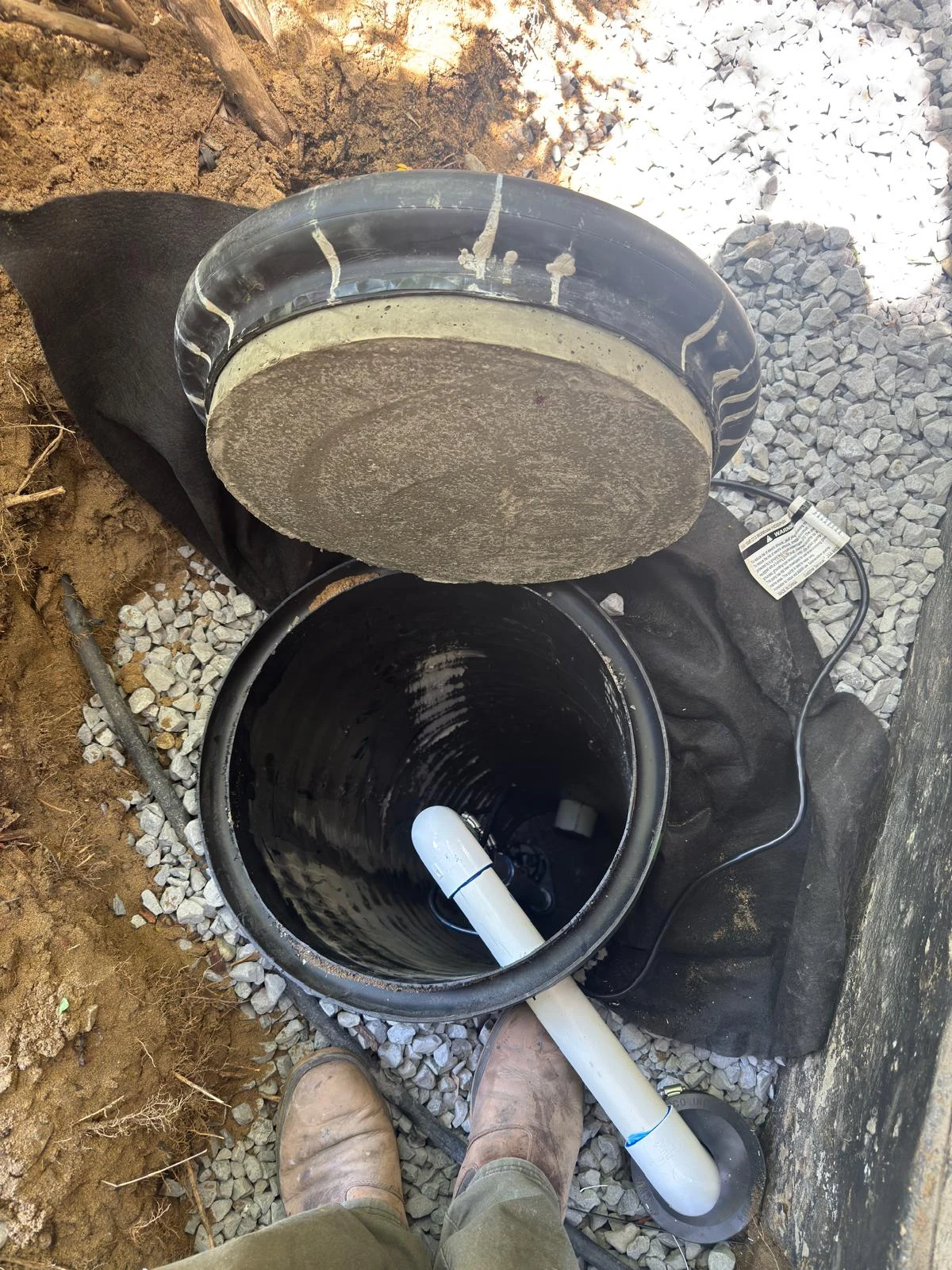 Open sump basin with connected piping during installation